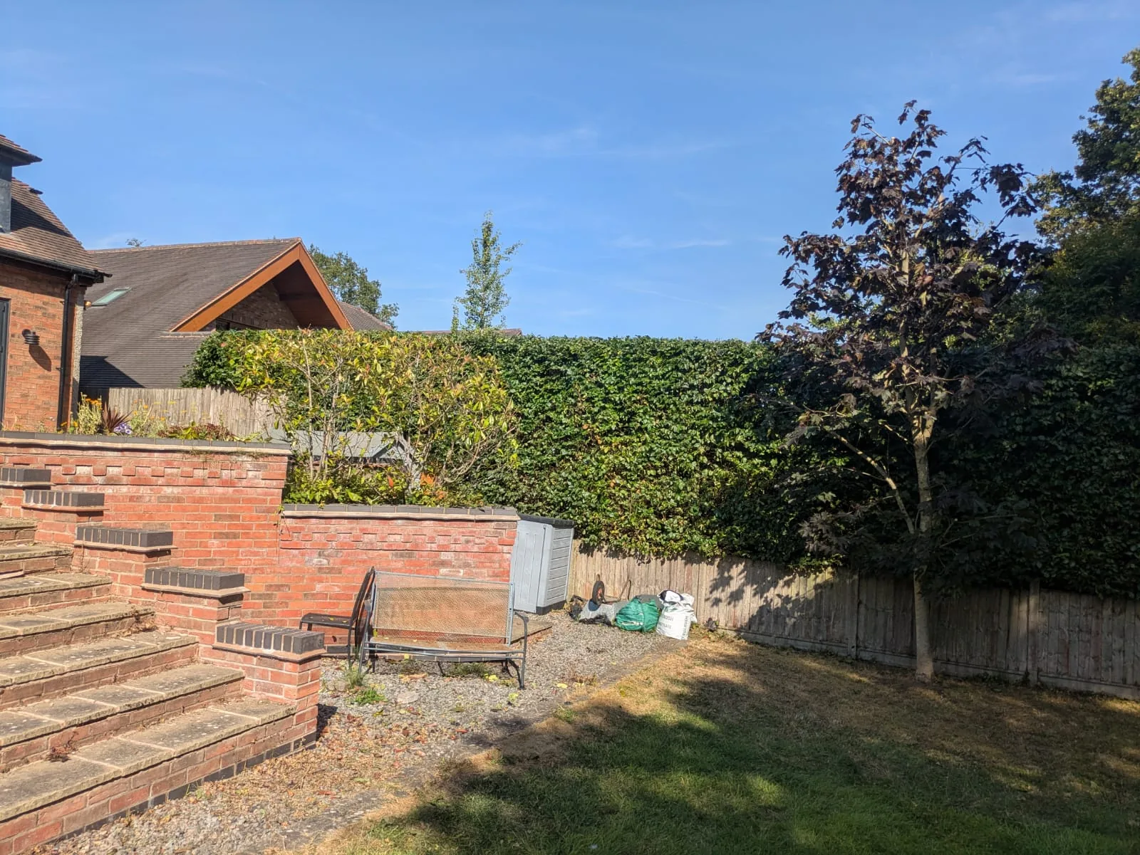 Freshly trimmed hedge beside brick garden steps